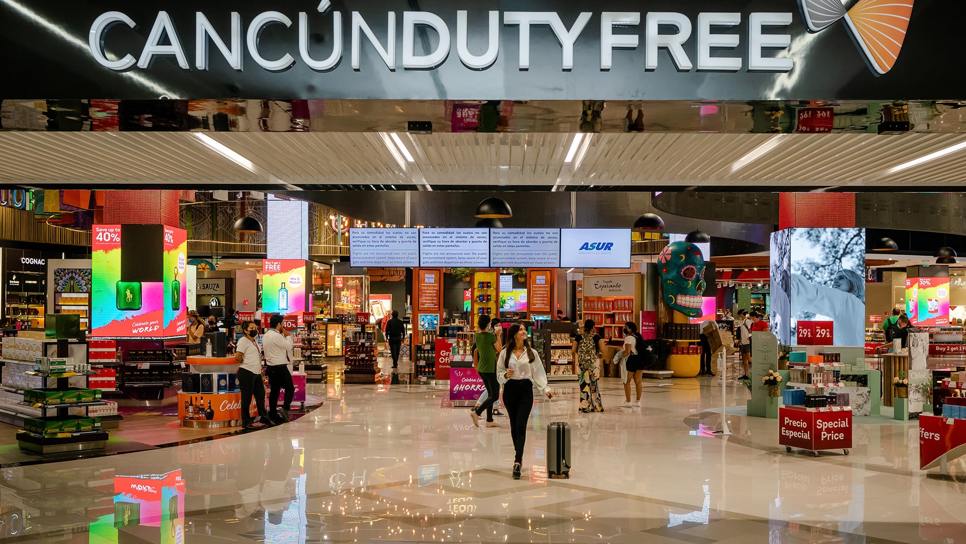Womans picture in front of Cancún Duty Free store inside Cancun's airport